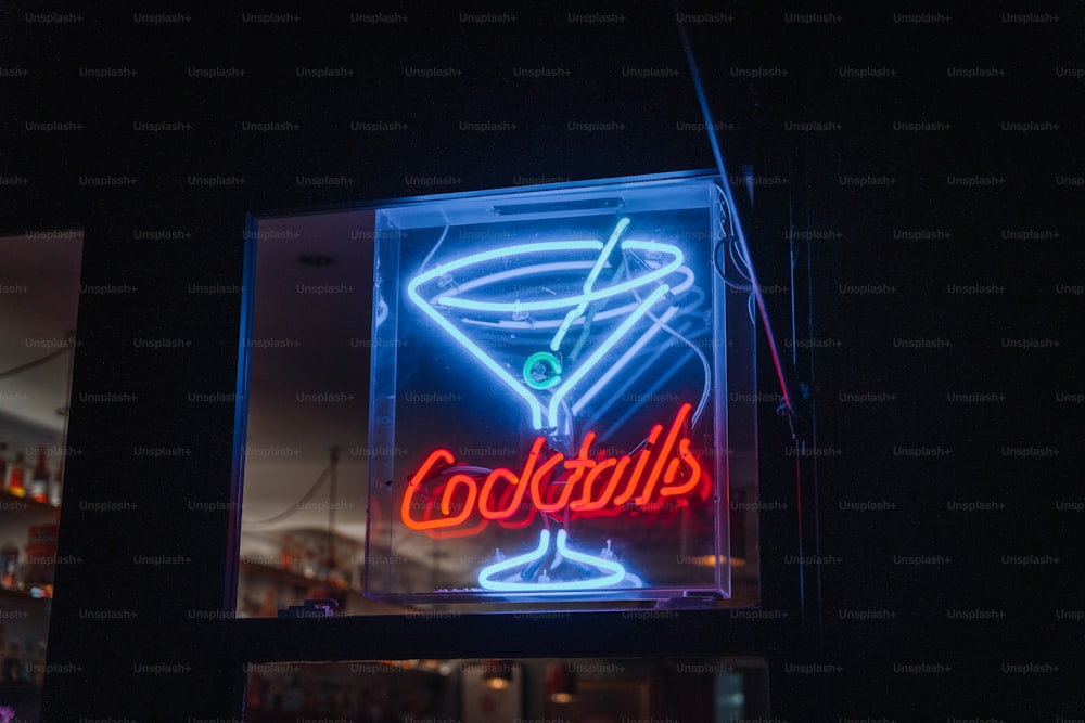 Un'insegna al neon che dice cocktail in un bicchiere