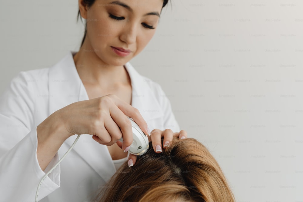 Una mujer está cortando el cabello de otra mujer con un secador de pelo