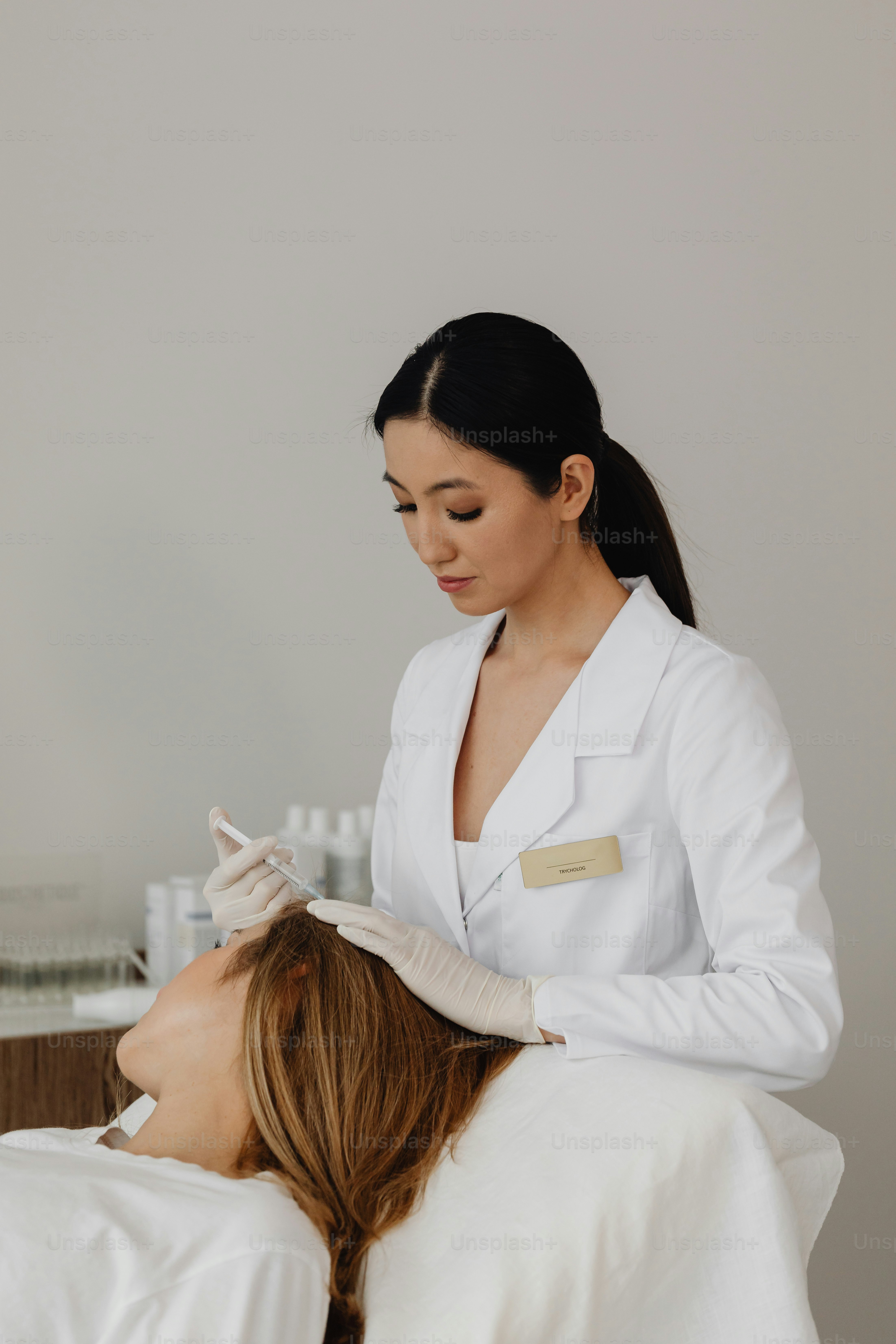 a woman getting her hair done by a hair stylist
