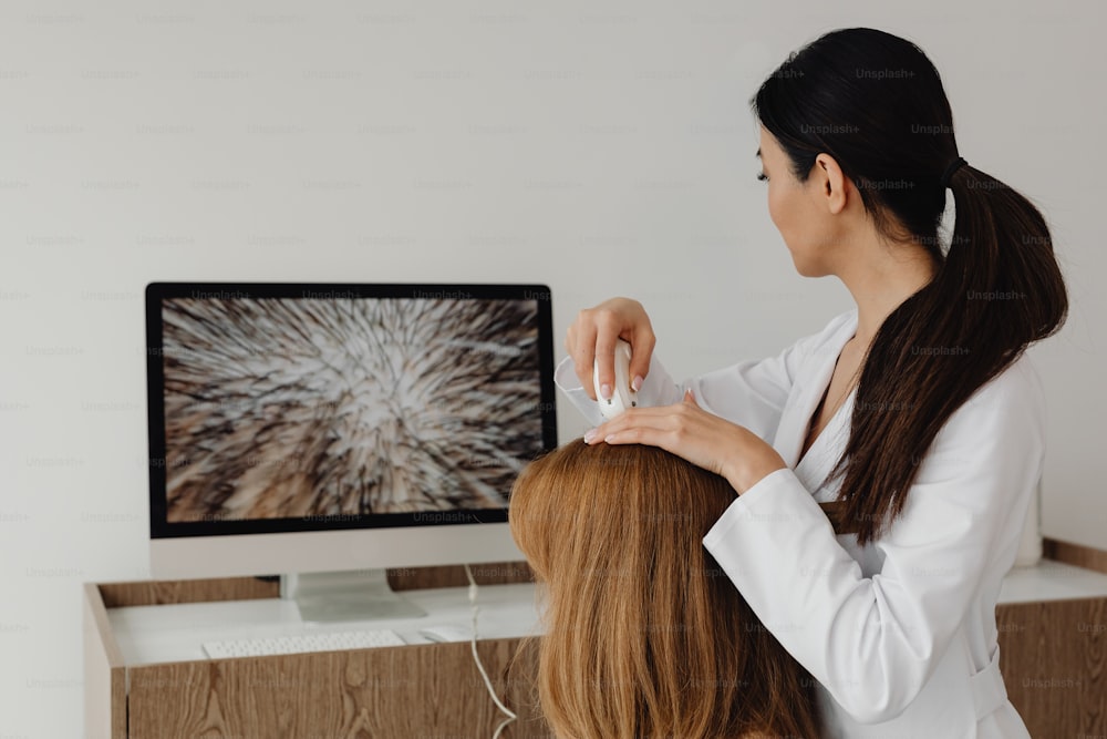 a woman is cutting another woman's hair in front of a computer
