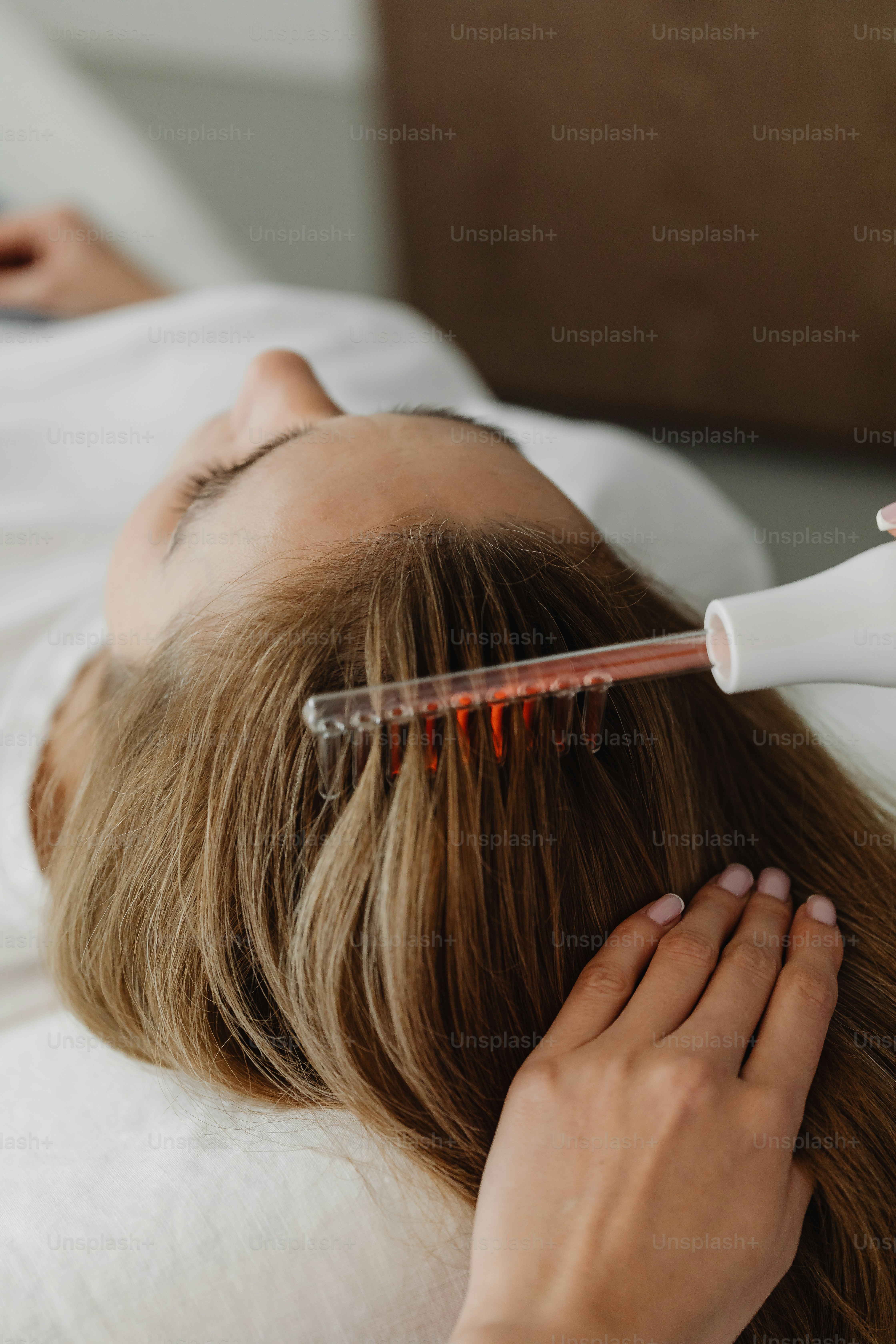 a woman laying on a bed while brushing her hair