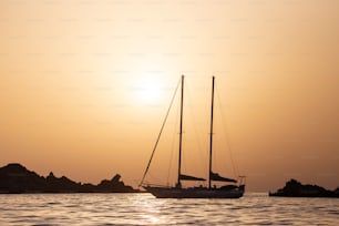 Ein Segelboot im Ozean bei Sonnenuntergang
