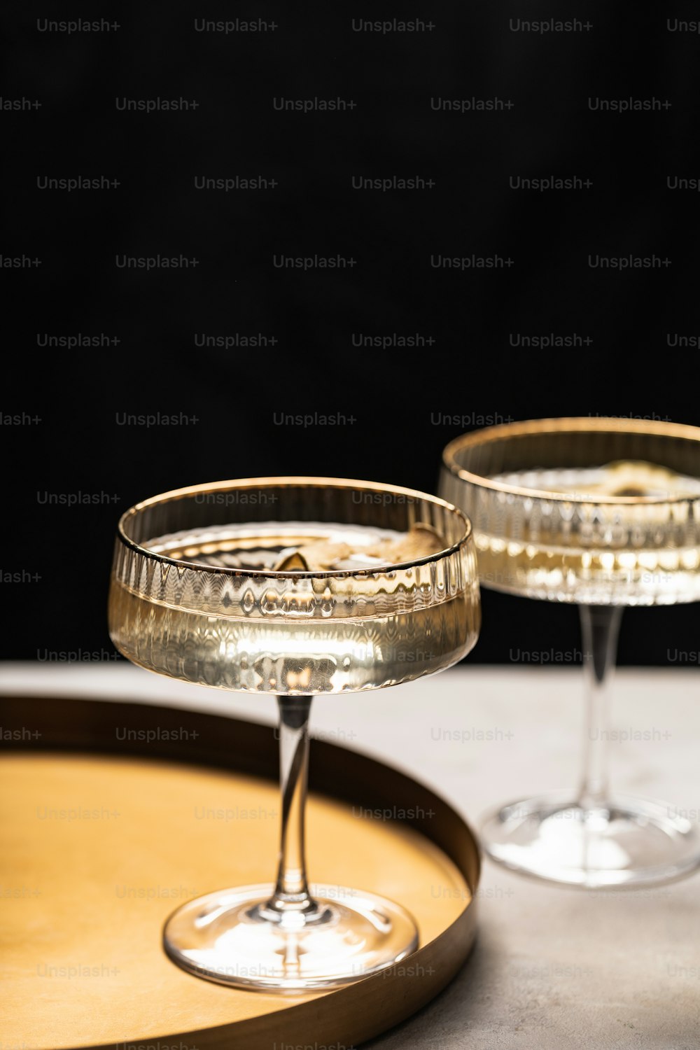 two empty wine glasses sitting on top of a wooden tray
