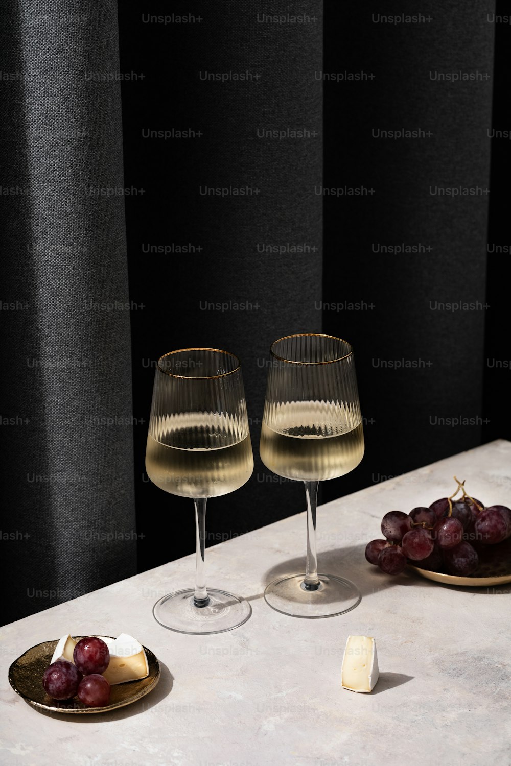 dois copos de vinho e queijo em uma mesa