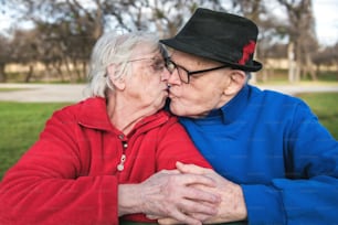 um homem e uma mulher se beijando em um parque