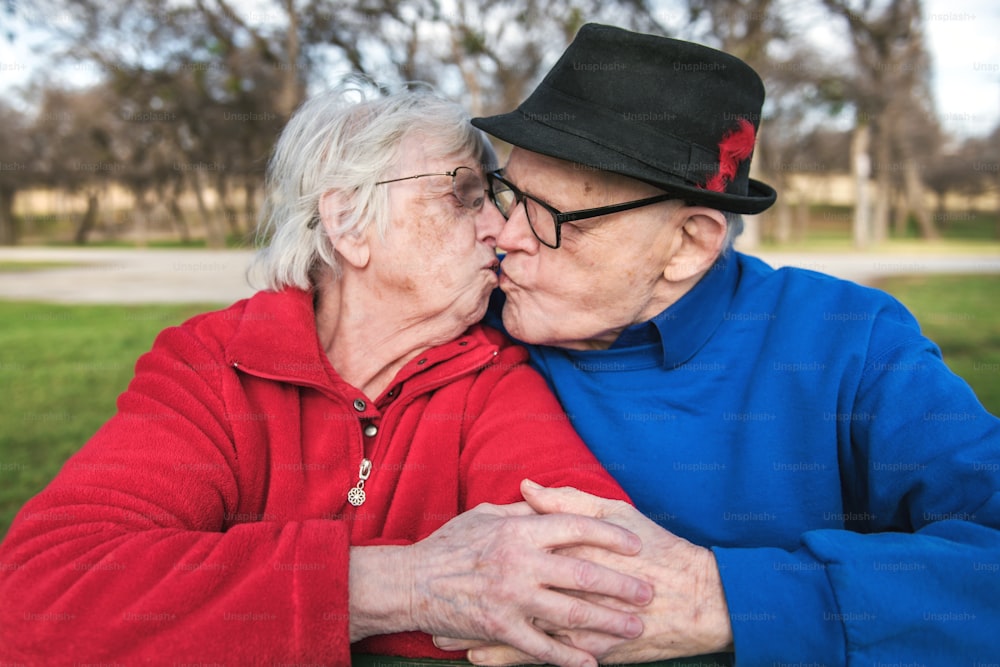 a man and woman kissing each other in a park