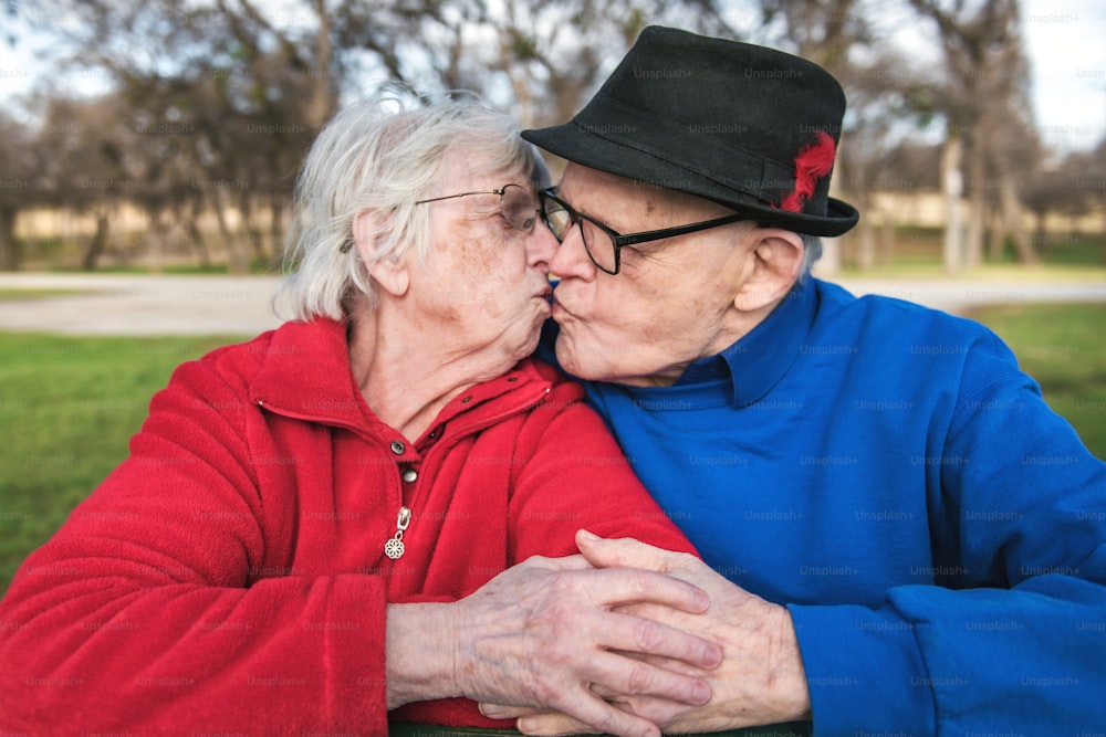 Un homme et une femme s’embrassent dans un parc