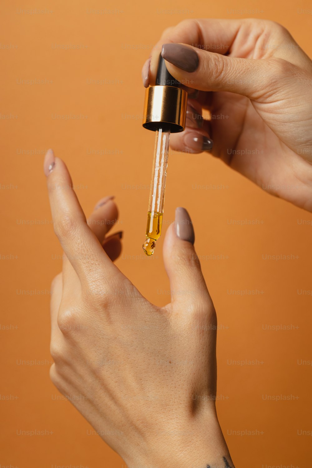 a woman holding a dropper in her right hand