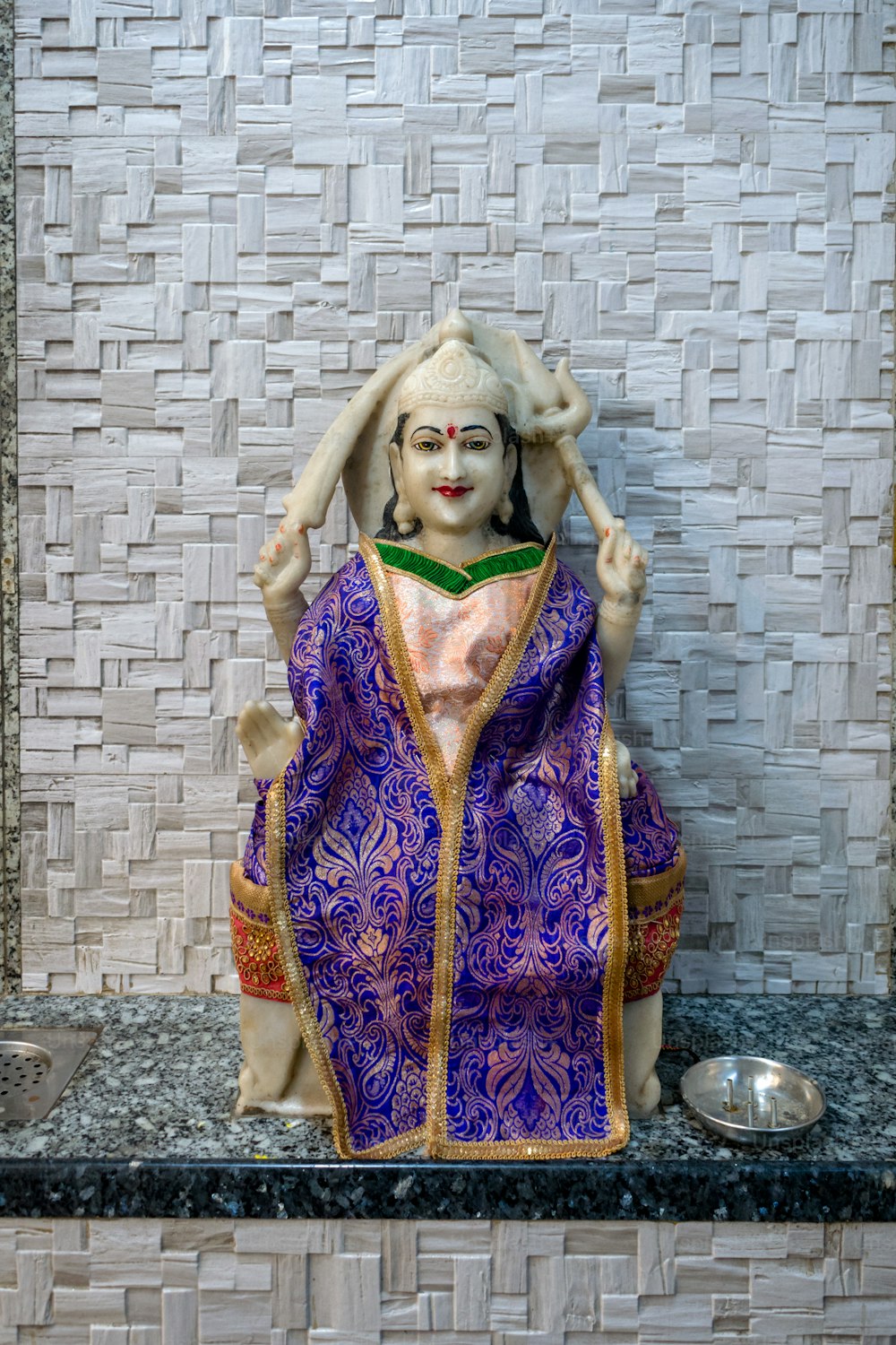 Une statue d’une femme en robe violette
