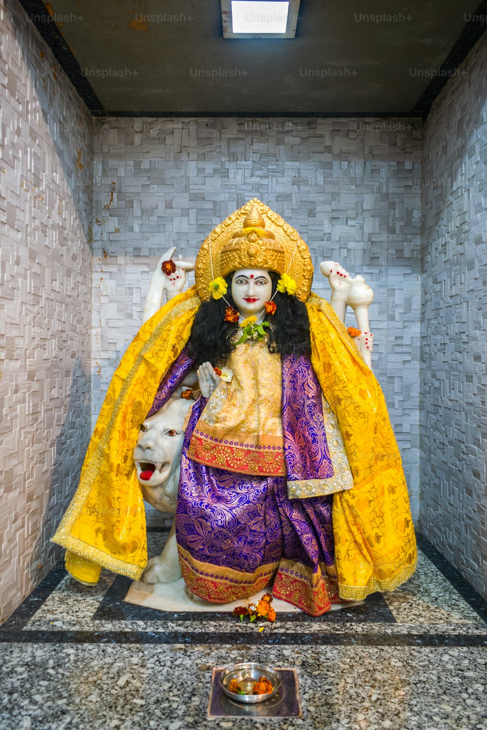 a statue of a woman in a yellow and purple outfit