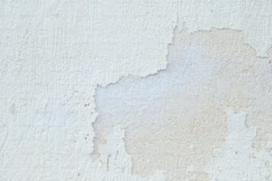 Un primer plano de una pared blanca con pintura descascarada
