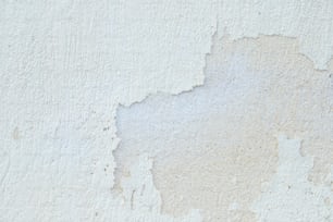 a close up of a white wall with peeling paint