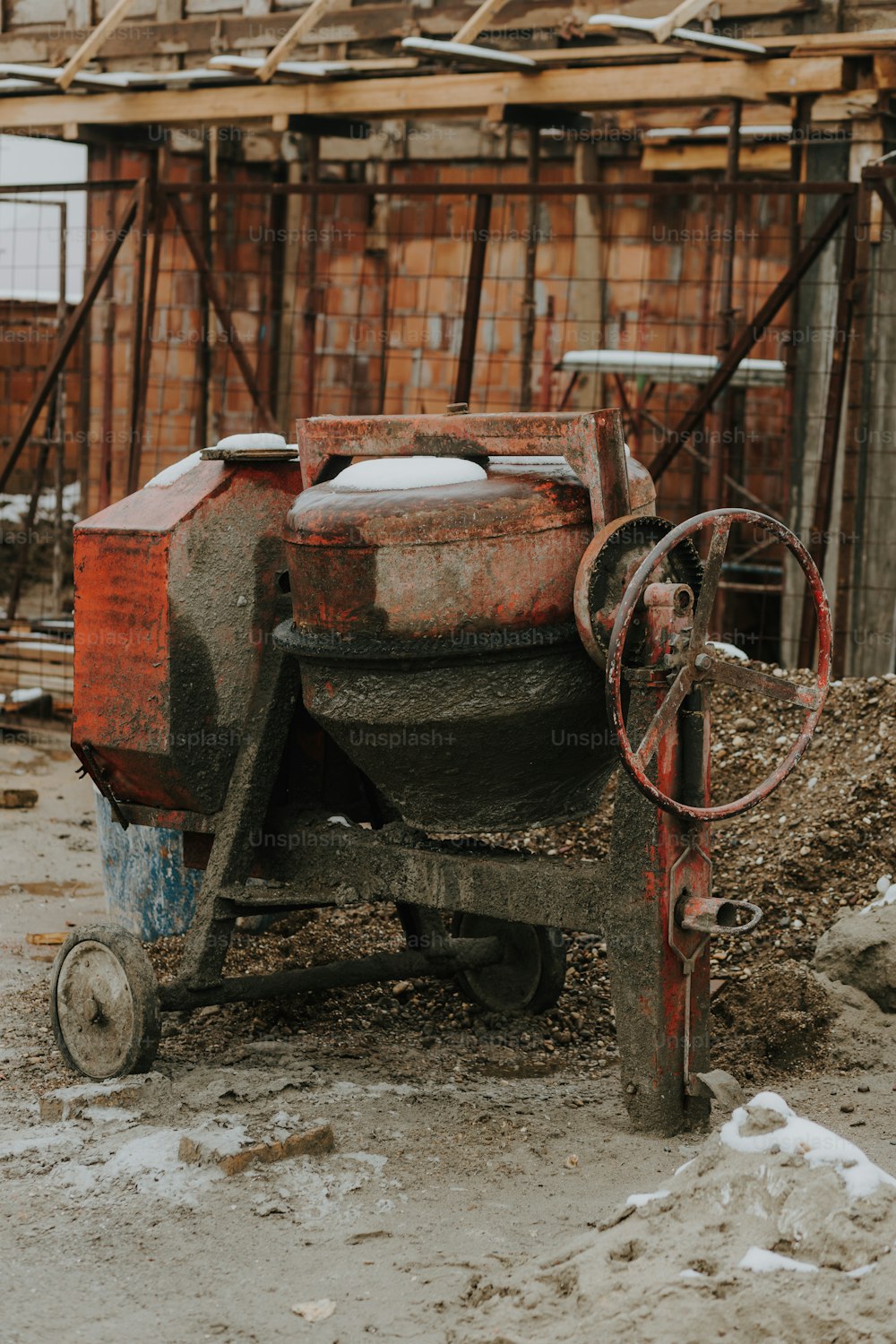 a red and black machine sitting on top of a pile of dirt