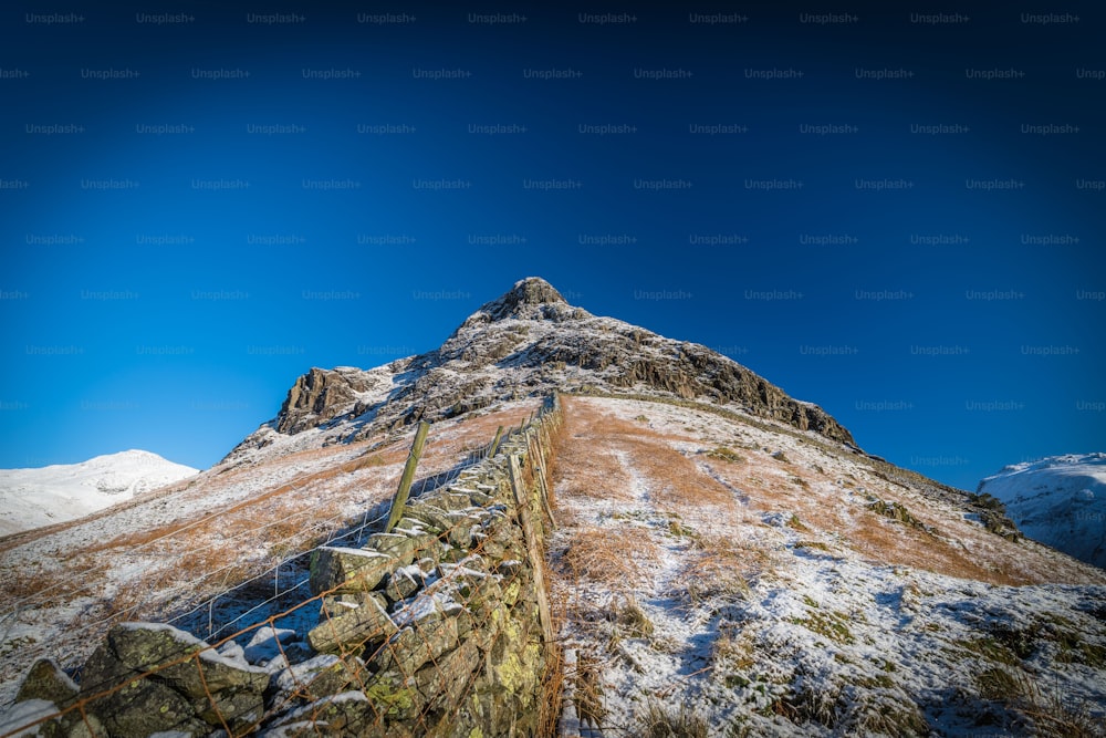 Ein sehr hoher Berg, der unter blauem Himmel schneebedeckt ist