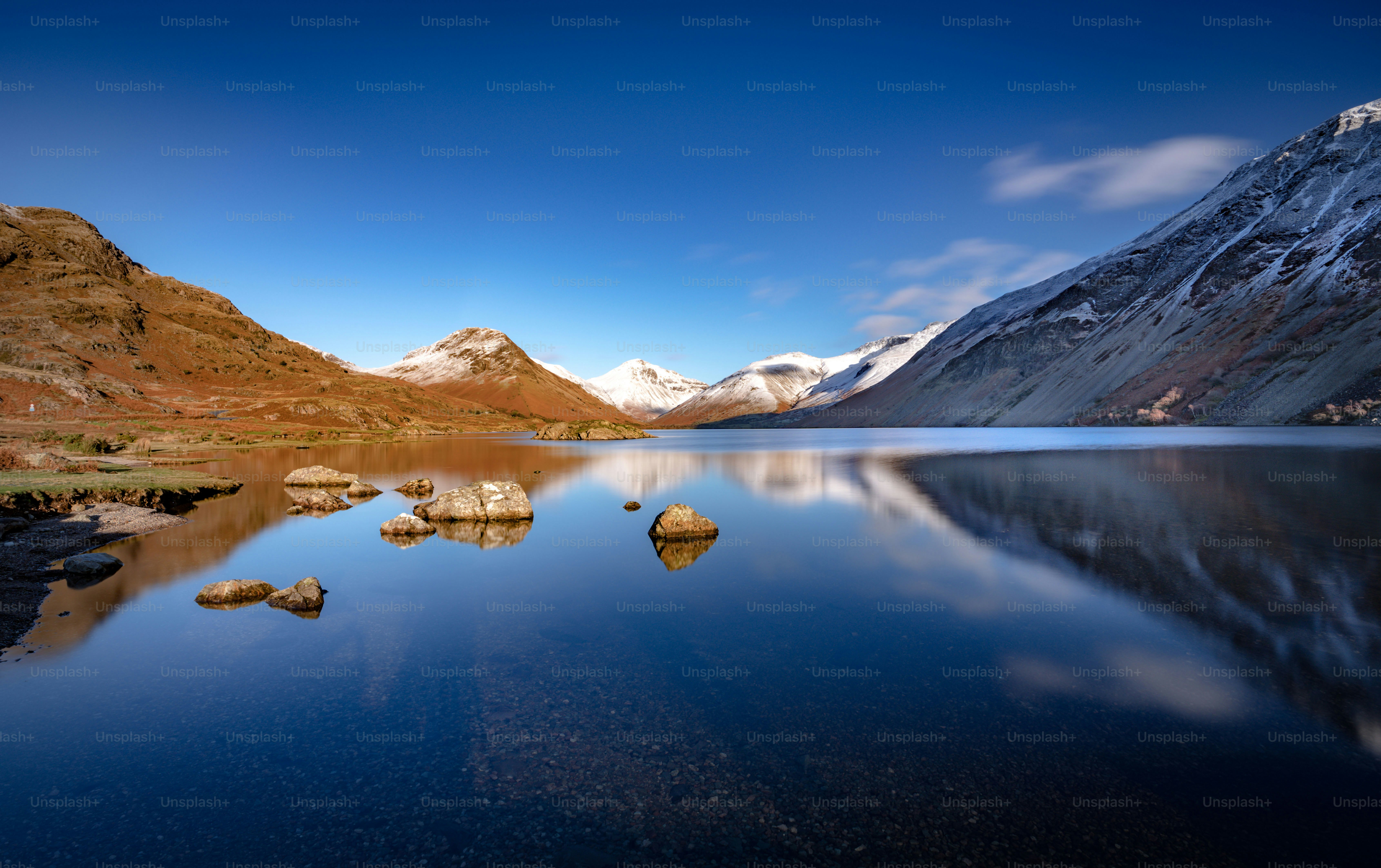Un lago circondato da montagne sotto un cielo blu