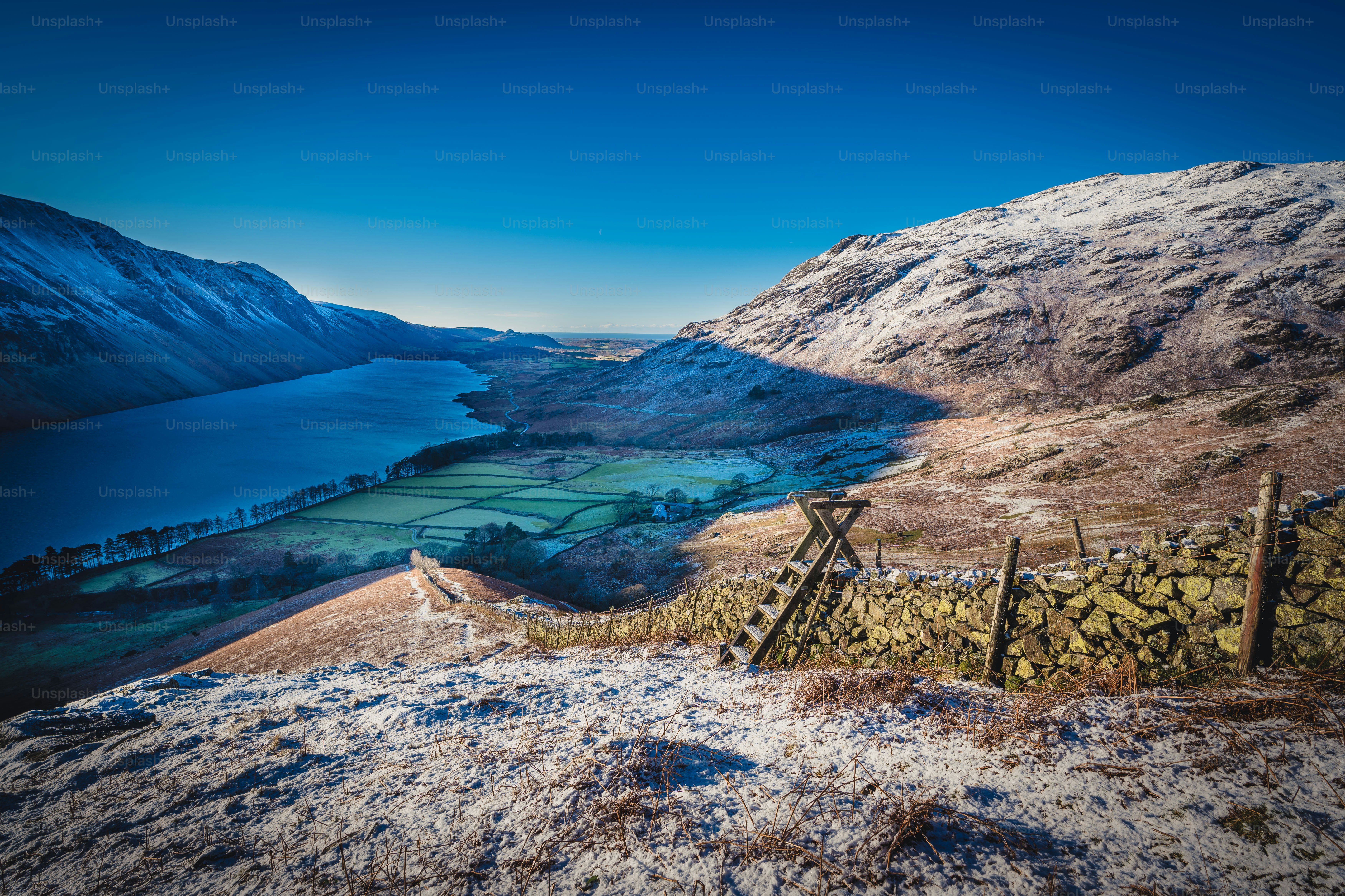 a view of a snowy mountain with a lake in the distance