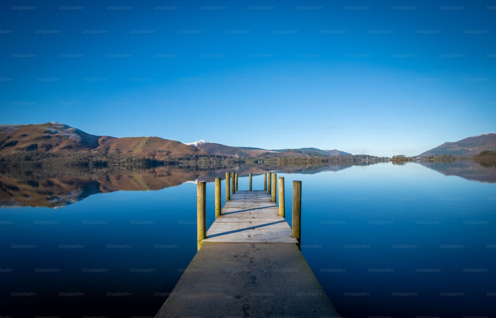 a dock on a lake with mountains in the background