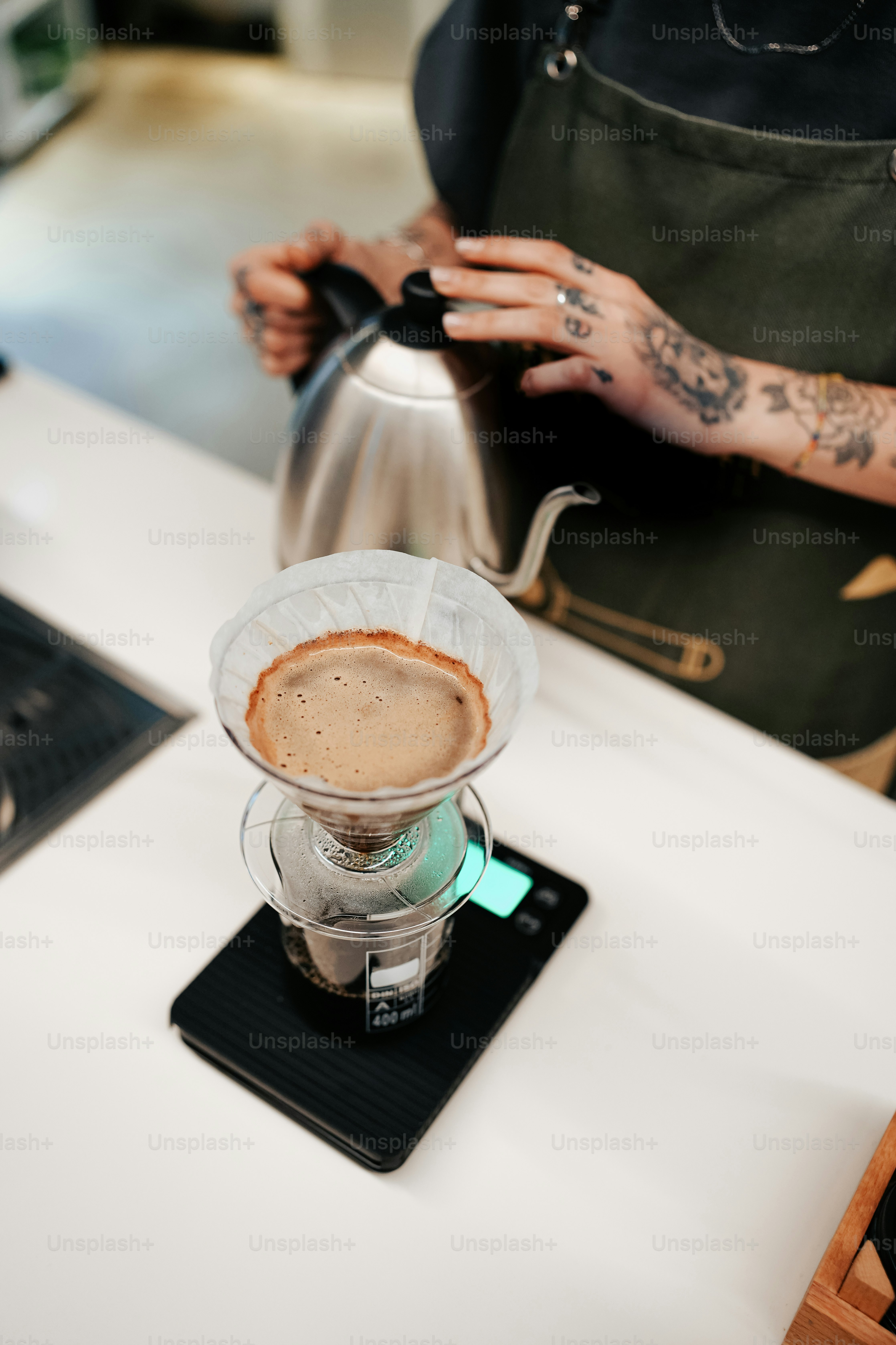 a person pouring a cup of coffee on top of a stove