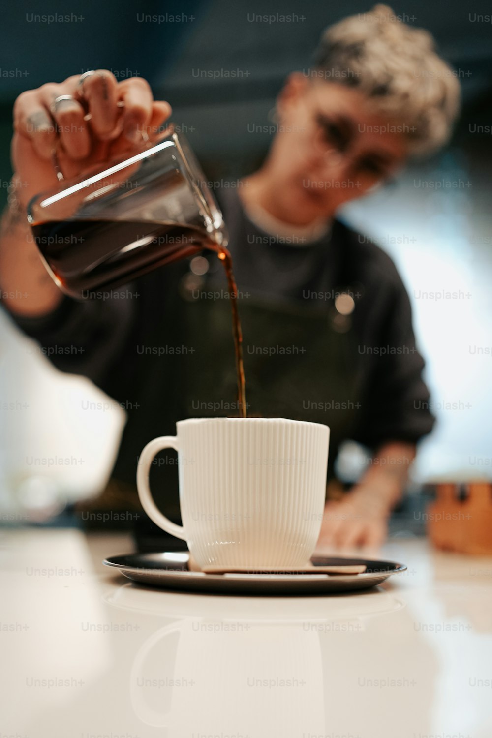 Un hombre vierte café en una taza