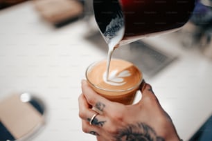 a person is pouring something into a cup