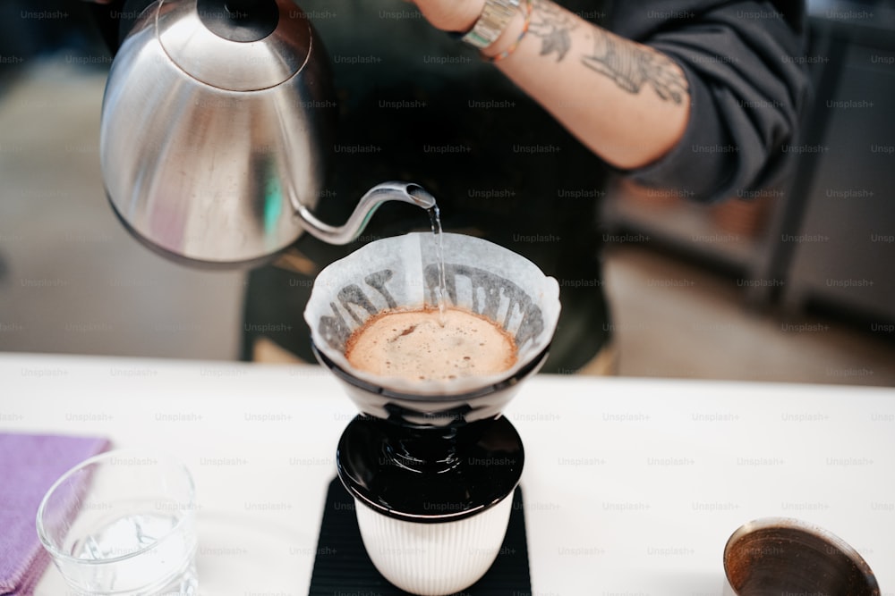 a person pours a cup of coffee