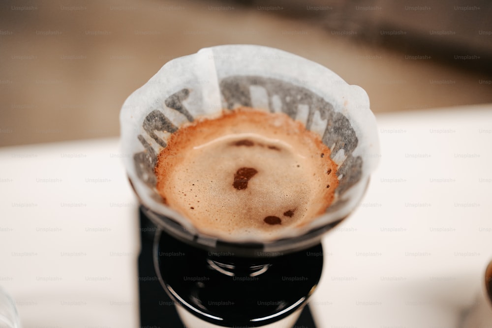una tazza di caffè seduta sopra una caffettiera