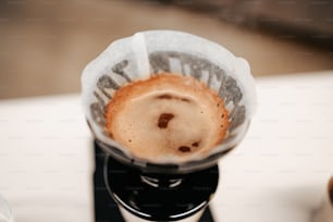 uma xícara de café sentada em cima de uma cafeteira