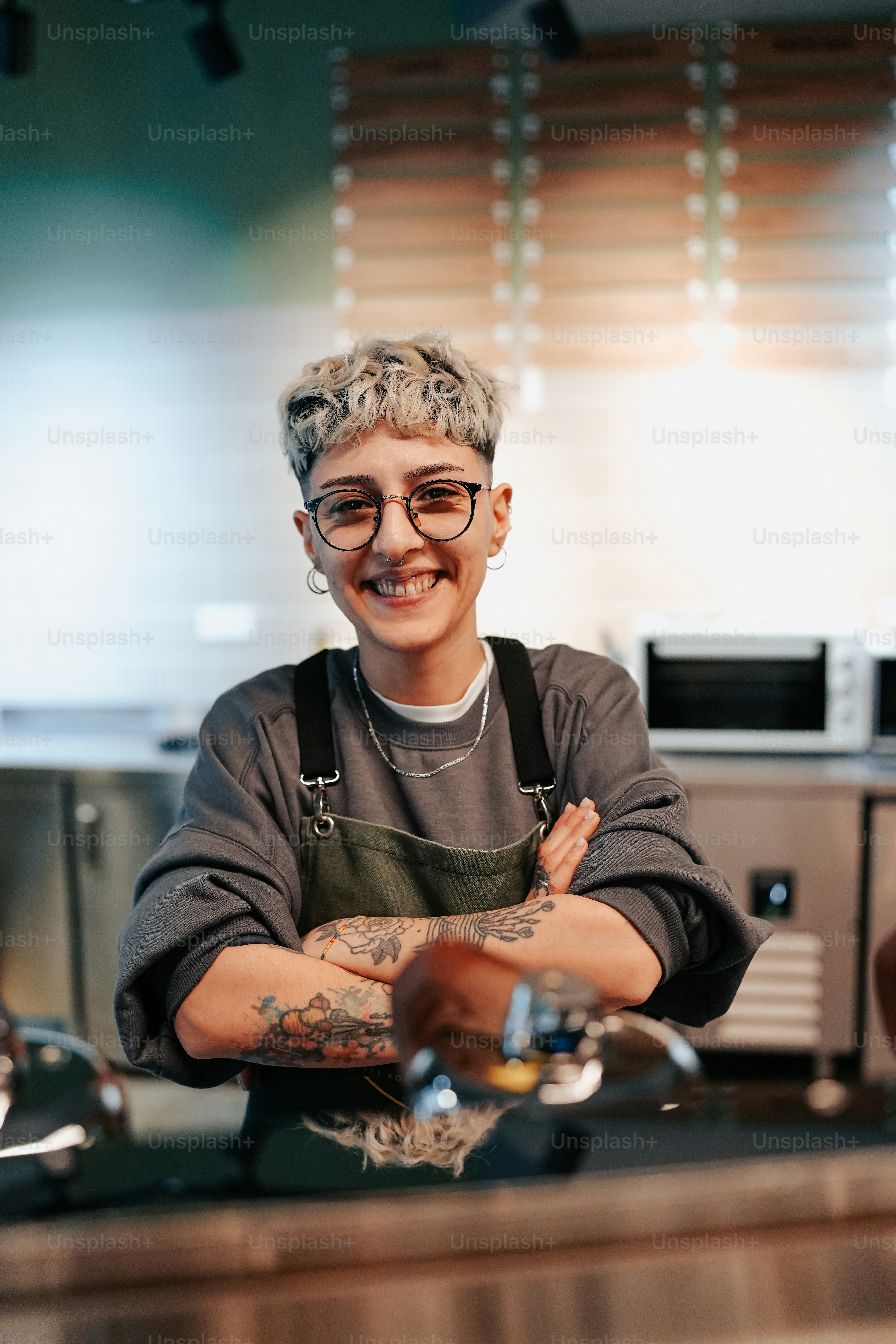 Eine Frau steht mit verschränkten Armen in einer Küche