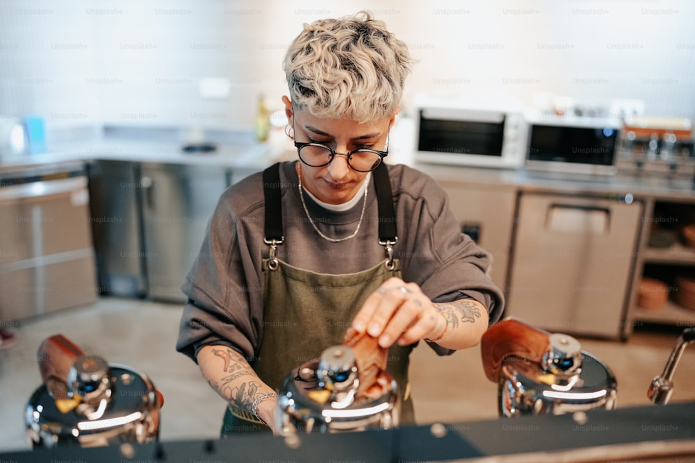 a woman in an apron is filling a cup of coffee