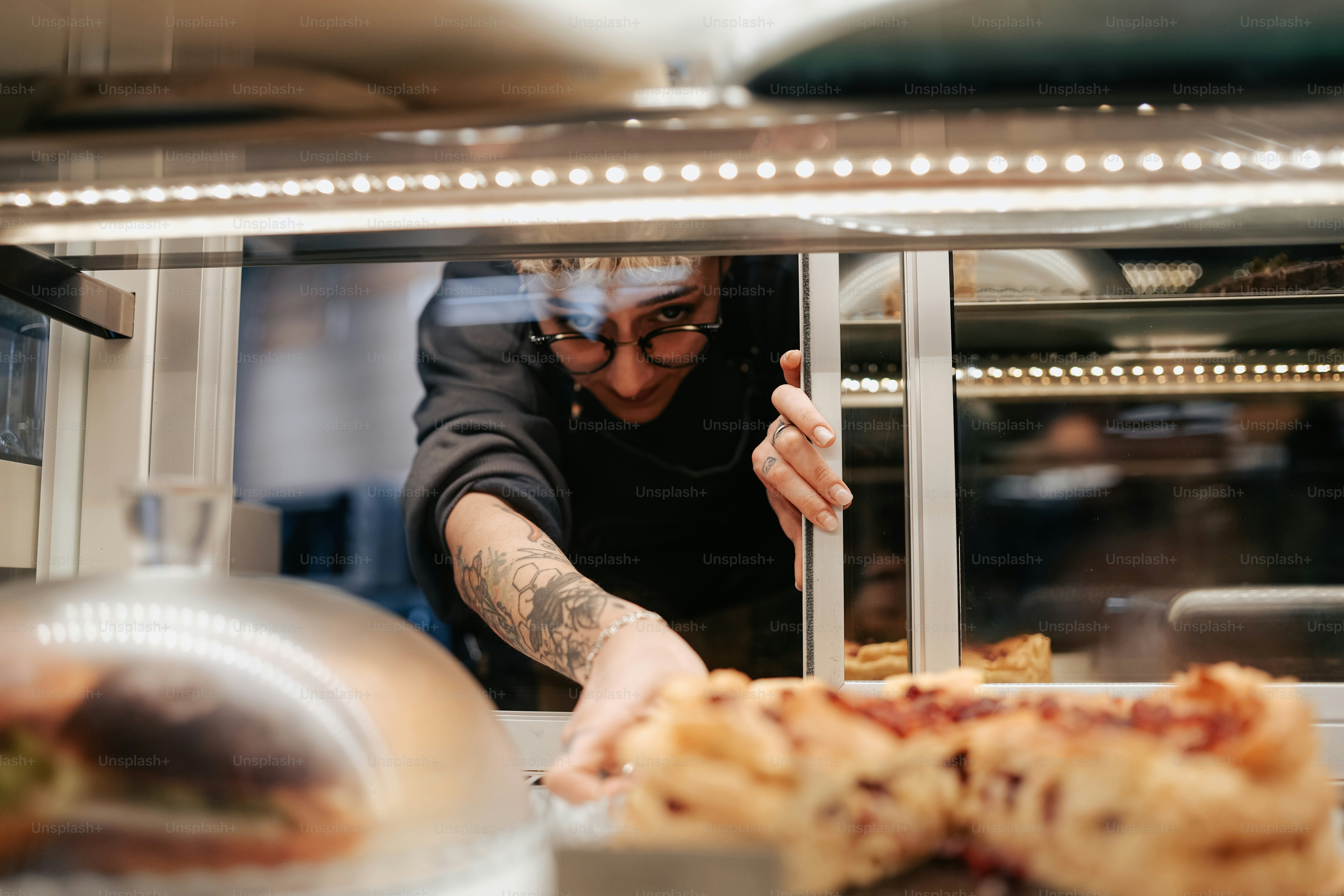 eine Person in einer Küche, die Essen auf einem Teller zubereitet