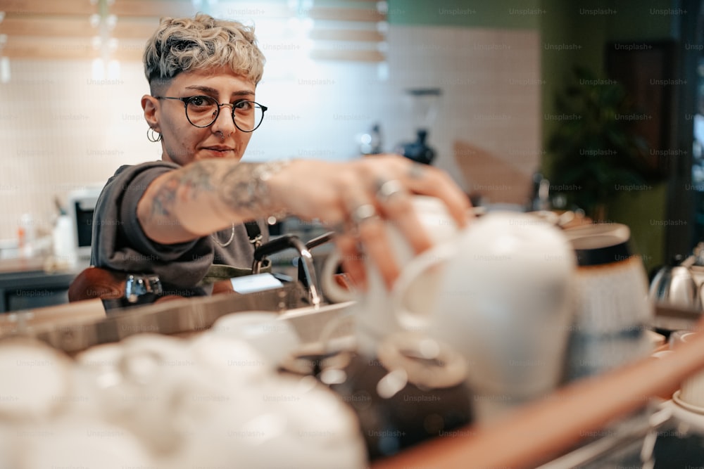 Une femme en lunettes verse une tasse de café