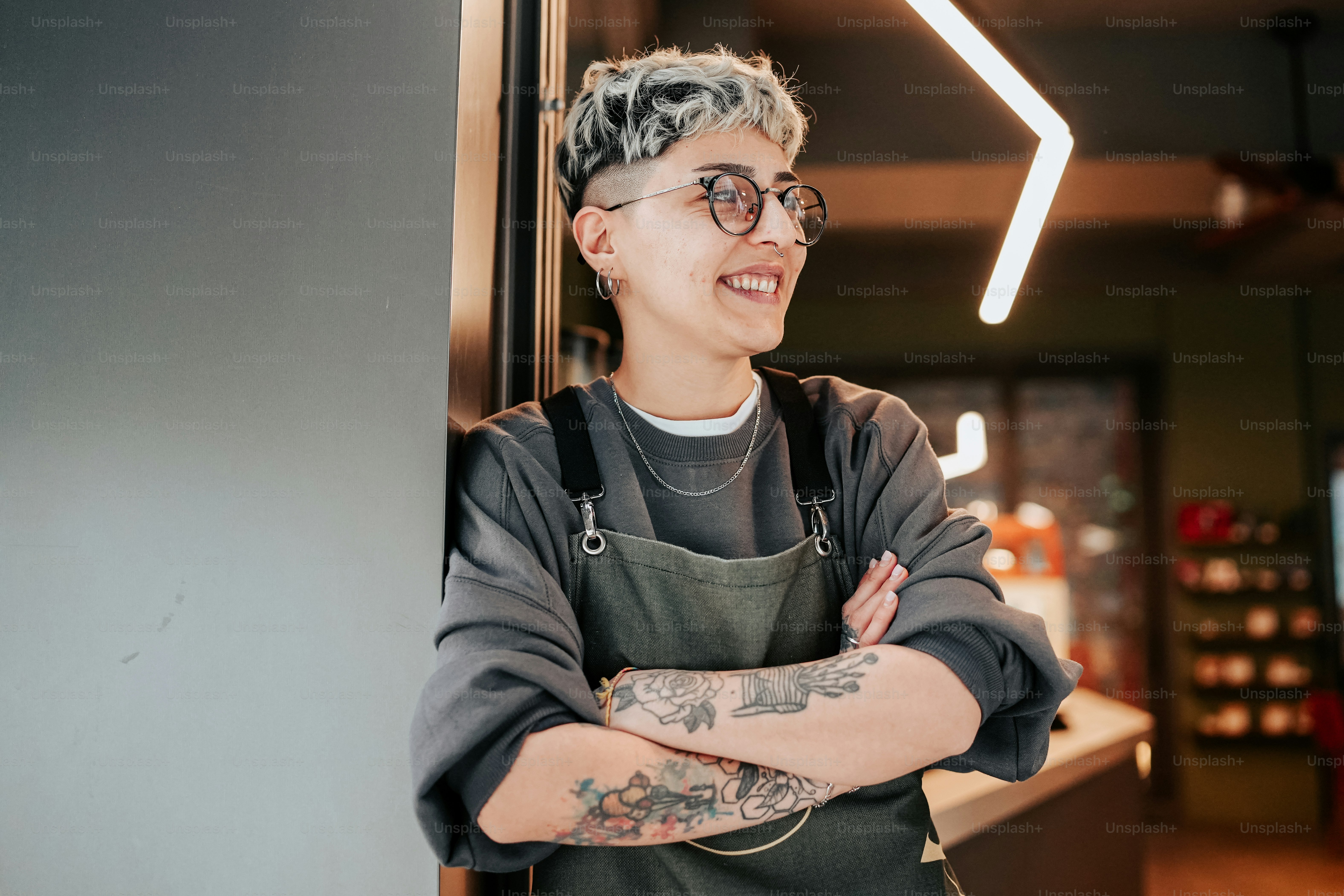 Eine Frau mit Tattoo auf dem Arm steht vor einem Tresen