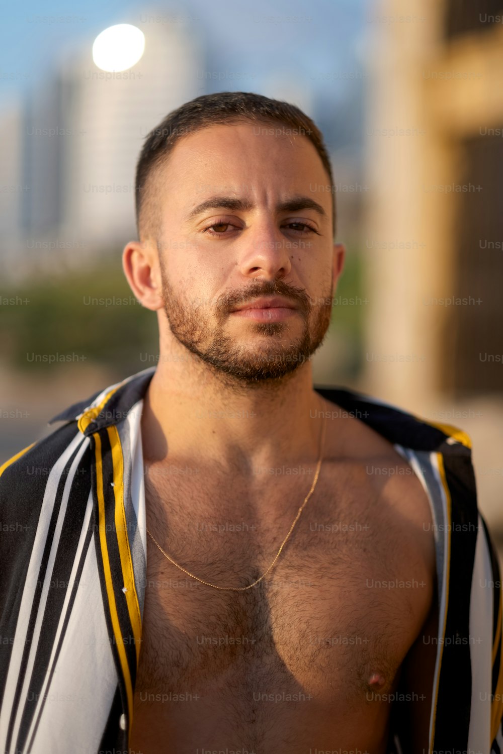 a man with no shirt on standing in front of a building