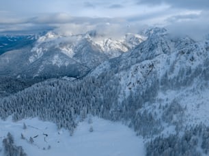 Blick auf einen verschneiten Berg mit Bäumen und Bergen im Hintergrund
