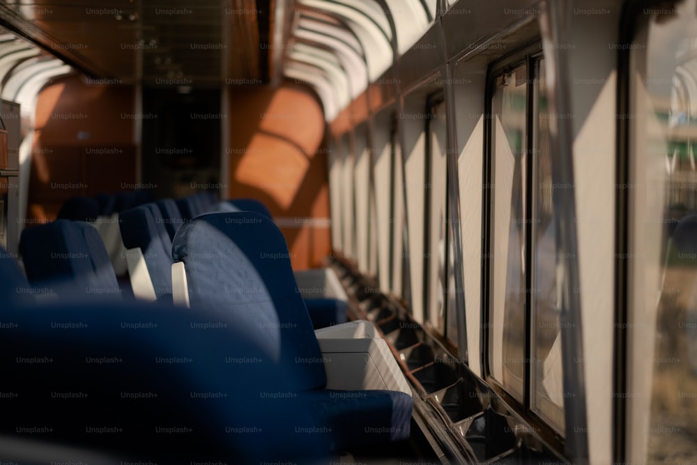 El interior de un tren con asientos azules