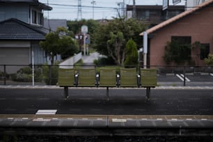 una panchina verde seduta sul ciglio di una strada