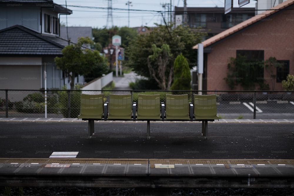 a green bench sitting on the side of a road