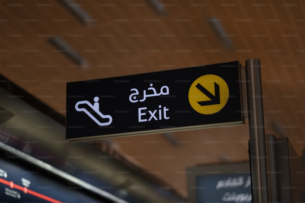 a black and yellow exit sign in a train station