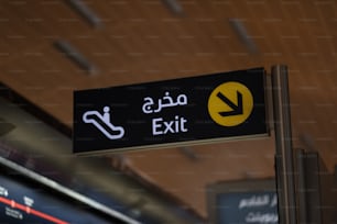 a black and yellow exit sign in a train station