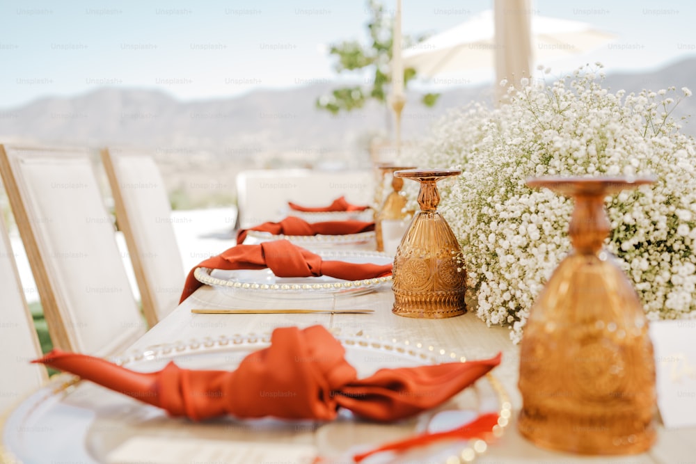 a table set for a formal dinner with red napkins