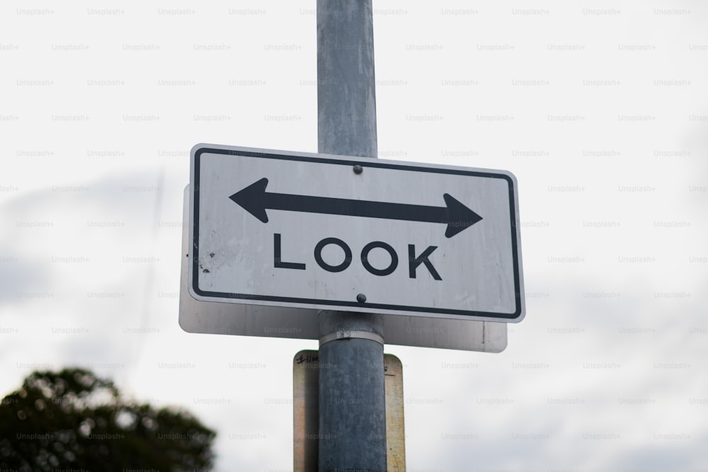 a close up of a street sign with trees in the background