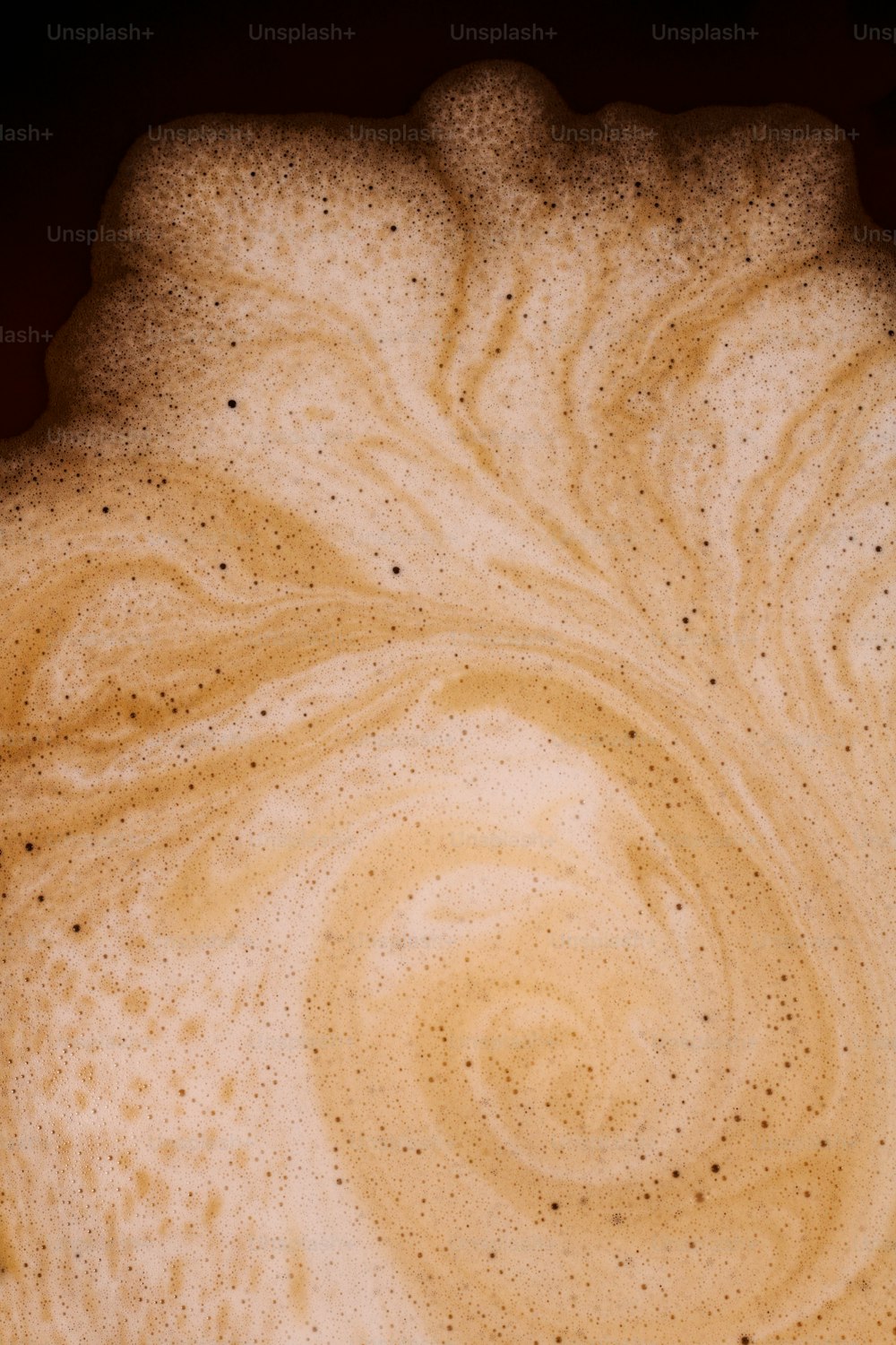 um close up de uma xícara de café com um padrão de redemoinho sobre ele