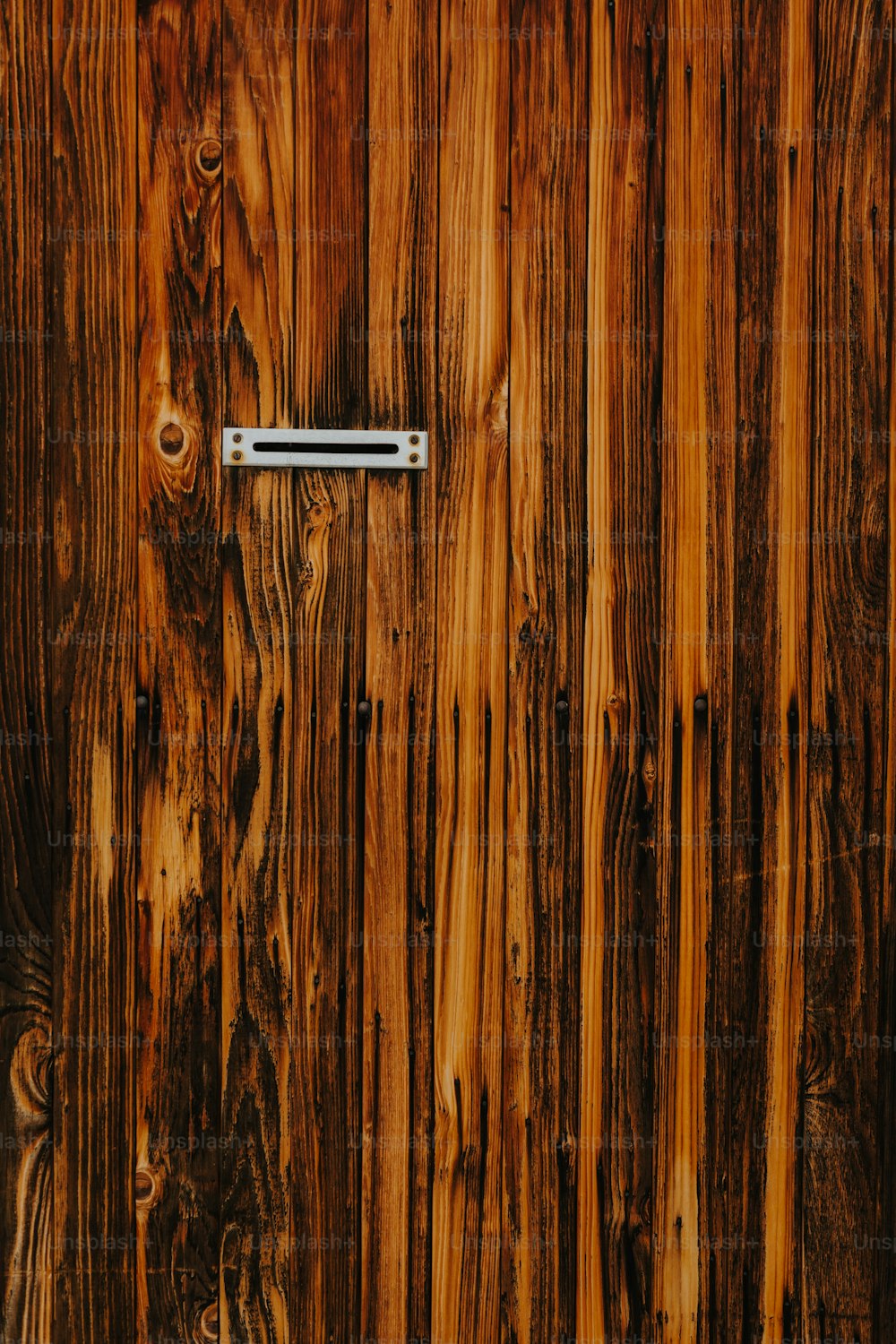 a close up of a wooden door with a metal handle