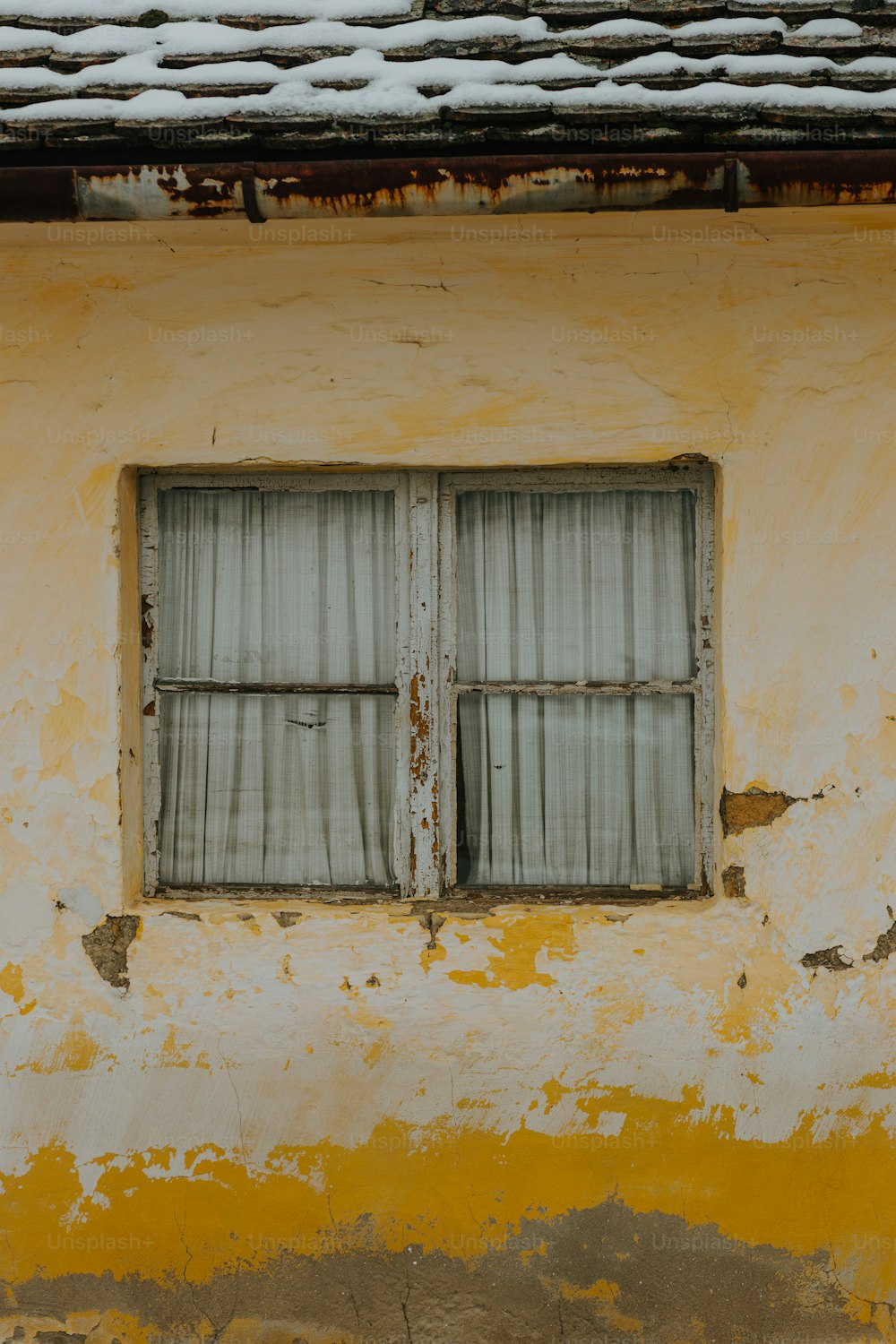 a yellow and white building with two windows