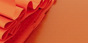 a stack of folded orange paper on an orange background