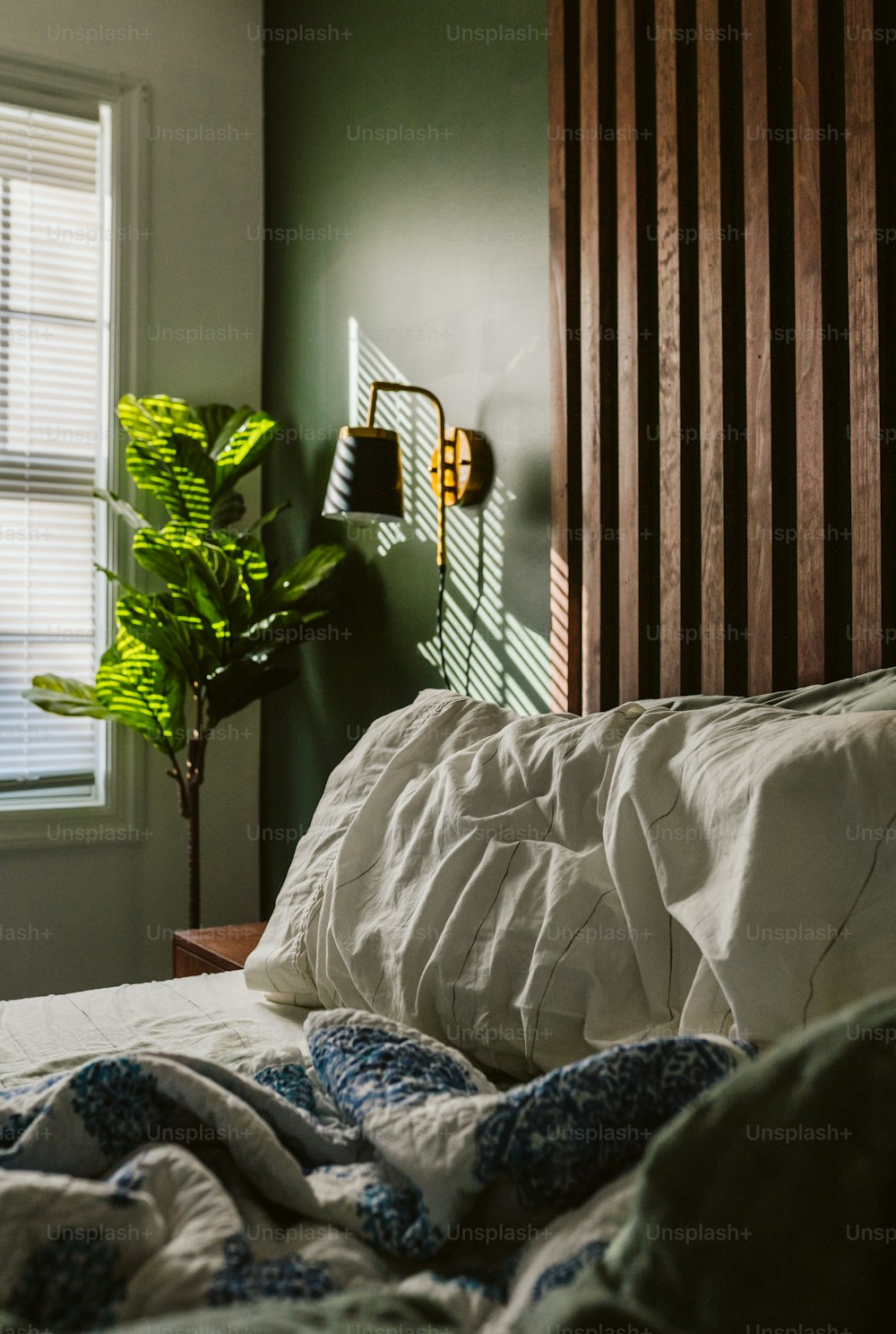 a bed with a white comforter next to a window