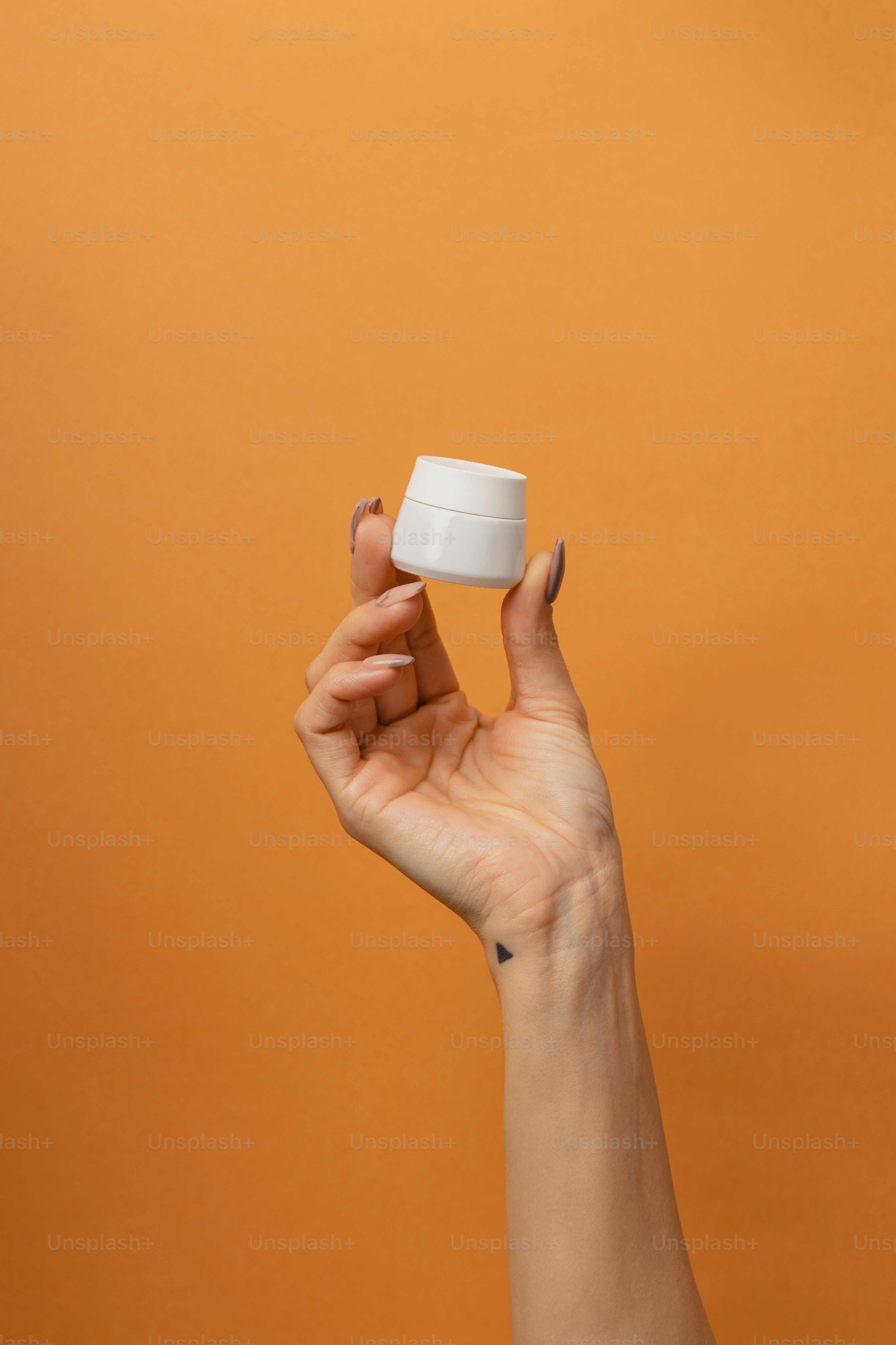 a hand holding a small white object in the air