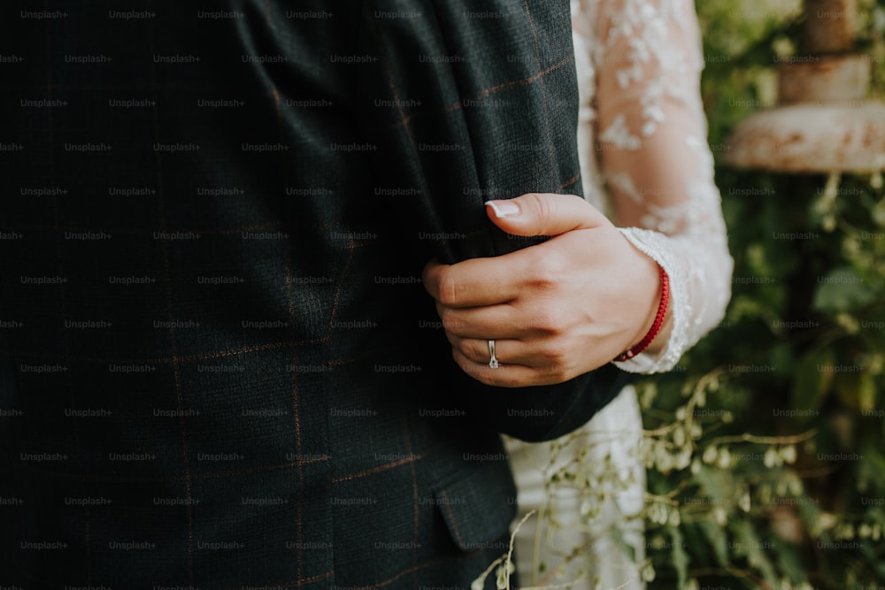 a close up of a bride and groom holding hands