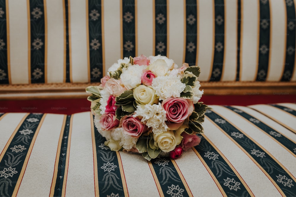 a bouquet of flowers sitting on top of a striped couch