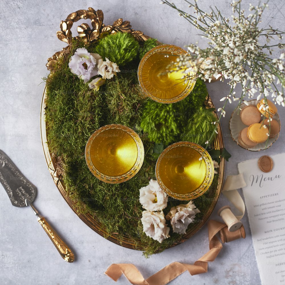 a tray with moss and gold cups on it